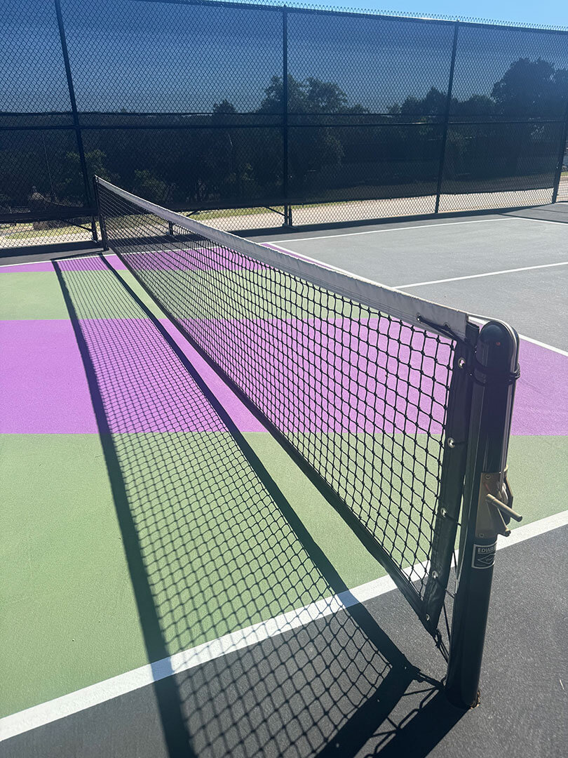 Upclose image of freshly installed pickleball court with custom colors and wind-resistant fencing